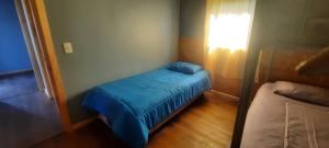 a small bedroom with a bed and a window at Cabaña Guzman in Villarrica