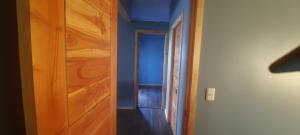a room with a wooden door and a hallway at Cabaña Guzman in Villarrica +6 photos