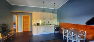 a kitchen with white cabinets and a table and chairs at Cabaña Guzman in Villarrica