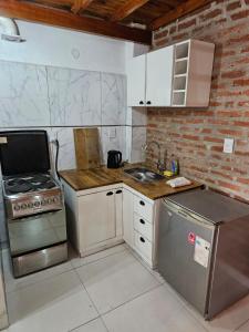 a kitchen with a stove and a sink at Acogedor loft estilo industrial in Posadas