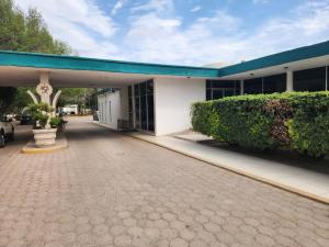 a building with a parking lot in front of it at Motel los Alpes in Ciudad Acuña