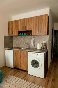 a kitchen with a washing machine and a sink at Студио 3 Слънчево Утро in Hisarya