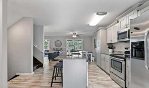 a kitchen with white cabinets and a kitchen island with chairs at 43 Making Memories in Leesburg
