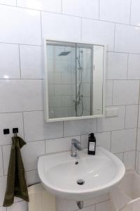 a bathroom with a white sink and a mirror at Modernes Apartment im Essener Stadtkern mit Parkplatz in Essen