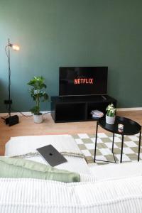 a living room with a bed and a tv at Modernes Apartment im Essener Stadtkern mit Parkplatz in Essen