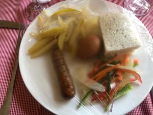 a white plate of food with a sandwich and vegetables at MableHomestay in Mzuzu