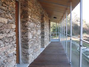 a walkway in a stone building with a stone wall at Quinta dos Castanheiros - Turismo Rural in Negreda