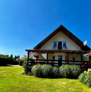 a house with a green lawn in front of it at Polańczyk Dom, Apartamenty - Leśny Domek Polańczyk in Polańczyk +58 photos
