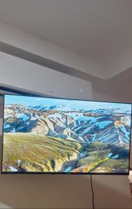a television screen with a picture of a mountain at Villa Amanda and Private Pool in Sampong