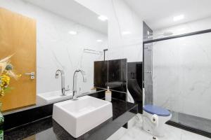 a bathroom with a sink and a toilet at Pousada Queiroz in Barra da Tijuca +26 photos
