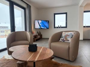 a living room with two chairs and a coffee table at Sportchalet Bergkristall regio Nassfeld Presseggersee in Kirchbach