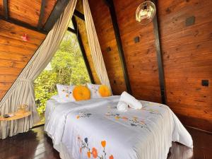 a bedroom with a bed in a room with a window at Romantic chalet with hot tub, fireplace, and view in São Pedro de Alcântara