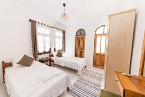 a white room with two beds and a mirror at Old Kalamaki Pansiyon in Kalkan