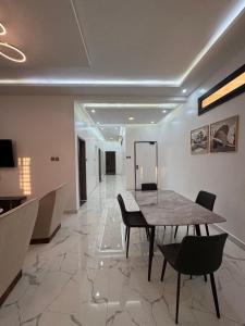 a dining room with a table and chairs and a hallway at Samaris Résidences in Nouakchott