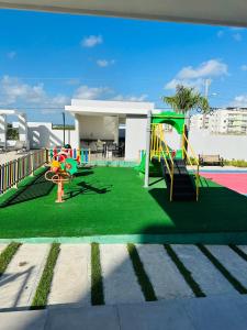 a playground with a slide on a green lawn at Residencia tropical jardines 3 in Punta Cana