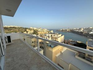 a balcony of a building with a view of the water at Serenità - Seaview Penthouse in Marsaskala