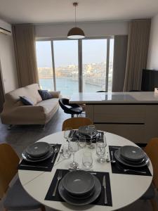 a living room with a table with plates and wine glasses at Serenità - Seaview Penthouse in Marsaskala