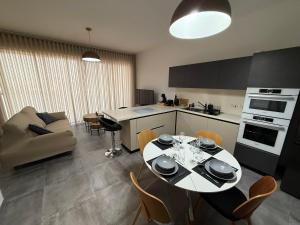 a kitchen and living room with a table and chairs at Serenità - Seaview Penthouse in Marsaskala +3 photos