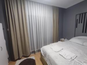 a bedroom with a white bed and a large window at Amasra Kerem Apart in Amasra