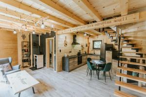 a log cabin with a spiral staircase and a table and chairs at Cisza Traw in Rabka-Zdroj