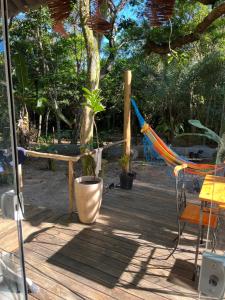 a hammock sitting on a wooden deck with plants at Reserva da Reserva Praia do Forte in Mata de Sao Joao +9 photos