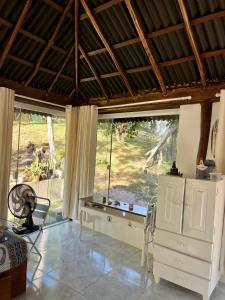 a living room with a large window and a white dresser at Reserva da Reserva Praia do Forte in Mata de Sao Joao