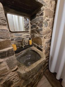 a stone bathroom with a sink and a mirror at Casa do Tear in Sobreira Formosa +15 photos