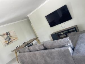 a living room with a couch and a flat screen tv at Luna Holiday Home in Maun