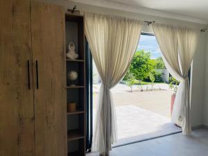 a room with a large window with curtains at Luna Holiday Home in Maun