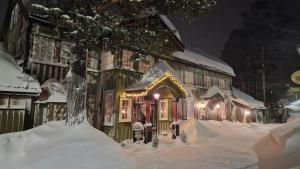 a house covered in snow with lights on it at Geilo Mountain Lodge in Geilo