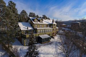 a large house with snow on top of it at Geilo Mountain Lodge in Geilo