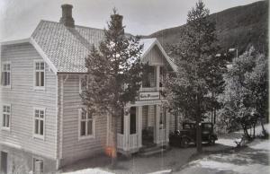 an old photo of a house with a truck in front at Geilo Mountain Lodge in Geilo