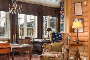 a living room with a chair and a couch and windows at Geilo Mountain Lodge in Geilo +18 photos