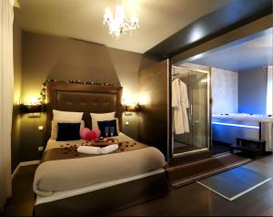 a bedroom with a large bed and a chandelier at Luxury & Love - Professional Jaccuzzi and Spa in Chelles