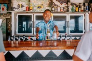 a man standing behind a bar with a drink at Beachcomber Island Resort in Beachcomber Island +67 photos