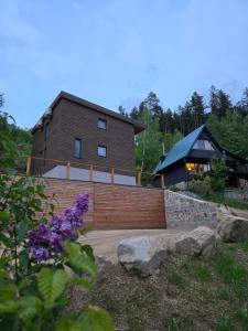 a house is shown with purple flowers in front of it at Hillside Cabin in Pomezí