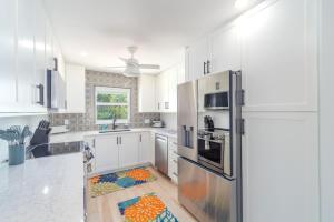 a kitchen with white cabinets and a refrigerator at Reel Caribbean Getaway in Summerland Key