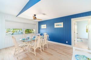 a dining room with blue walls and a table and chairs at Reel Caribbean Getaway in Summerland Key