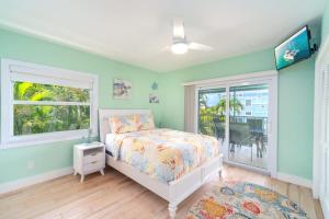 a bedroom with a bed and a window at Reel Caribbean Getaway in Summerland Key