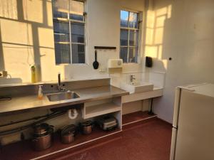 a kitchen with two sinks and two windows at Urban Lounge Sleepery Carterton in Carterton +85 photos