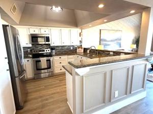 a kitchen with white cabinets and stainless steel appliances at Lake Vibes with Champagne Views in Montgomery