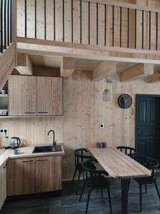 a kitchen with wooden cabinets and a wooden table at Hillside Cabin in Pomezí