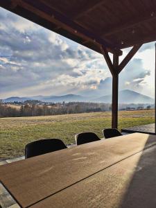 a table with chairs and a view of a field at Górska Stodoła - Domek z Prywatnym Jacuzzi in Lipowa +40 photos
