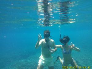 two people swimming in the water in the ocean at Mares Homestay-Raja Ampat in Fam