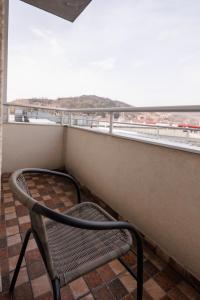 a chair sitting on a balcony looking out at the ocean at MaxInn 14 in Pirot