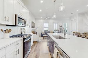 a kitchen with white cabinets and a counter top at The Fairway Farmhouse in Port Aransas