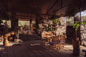 a patio with a table and chairs on a wooden deck at Cabaña Romántica, glamping Piedra Braza Orígenes in Ocoyoacac