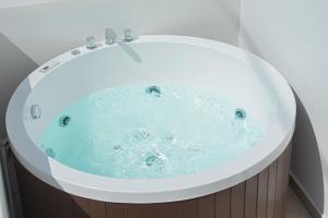 a white bath tub with blue water in it at Santo Evdokia in Vóthon +29 photos