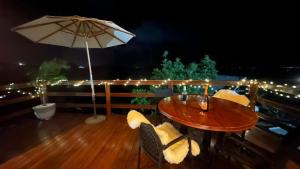 a wooden table with chairs and an umbrella on a deck at Fabulosas da Serra in Monte das Gameleiras +6 photos