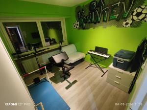 a living room with a green wall and a keyboard at Casa 28 in Kapelle-op-den-Bos